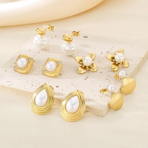 Detailed view of four pairs of gold pearl earrings in square and floral designs