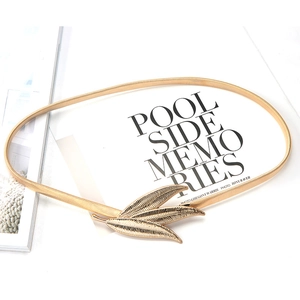 Elegant gold metal spring waist belt featuring a decorative feather buckle for dresses