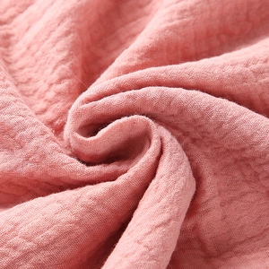 Pink double-layer cotton muslin baby swaddle blanket with soft wrinkled texture