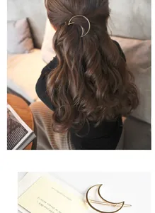 Detail of a crescent moon-shaped golden alloy hair clip on wavy brown hair