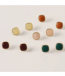 Macro shot of colorful square resin earrings with gold metal frame in various colors