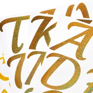 Macro view of 3-inch golden glitter alphabet and number stickers with sparkling texture
