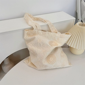 Detail of French style floral embroidery and soft texture on cream canvas tote bag