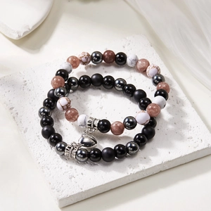 Detailed macro view of natural stone couple bracelets with magnetic heart and silver crowns