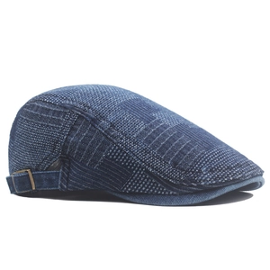 Detail view of denim flat cap featuring mixed textures and vintage bronze metal side buckle