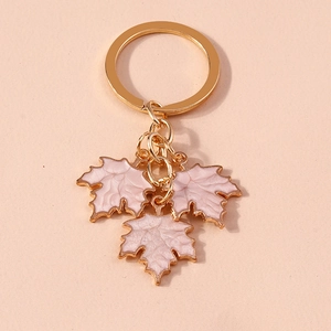 Close-up of golden keychain featuring three textured pink enamel maple leaf pendants