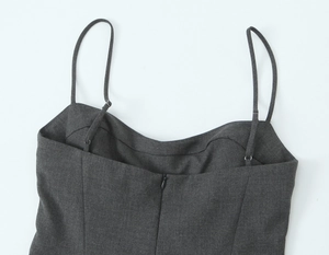 Détail d'une robe grise à bretelles montrant le tissu texturé et le zip invisible