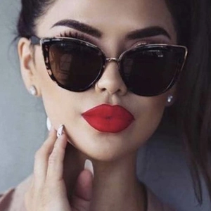 Chic cat-eye sunglasses with tortoise shell frames and dark lenses worn by model