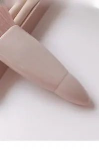 Close-up of soft pink makeup brush bristles and glossy handles in a set