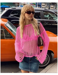 Detail of pink crochet knit beach cover-up with flared sleeves and hollow-out pattern