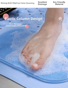 Detail of light blue anti-slip bathroom mat with massaging columns and drainage holes