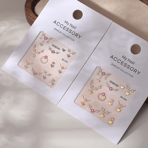 Close-up of MJ-041 nail art jewelry set featuring crystals, hearts and gold accents