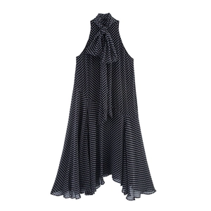 Detail of black polka dot sleeveless halter dress featuring a large decorative bow tie neck