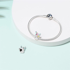 Close-up of silver snake chain bracelet featuring a colorful enamel paintbrush holder charm