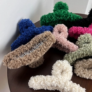 Macro view of plush velvet texture on oversized hair claws in various vibrant colors