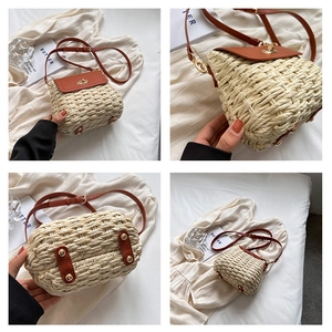 Detail view of khaki straw crossbody bag showing leather flap and golden twist lock