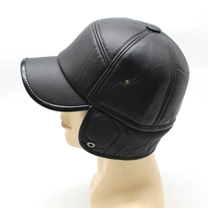 Detail of black leather winter hat featuring windproof ear flaps and textured finish