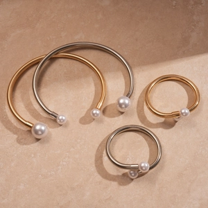 Elegant metallic coil necklace and bracelet set featuring faux pearl ends in gold and silver
