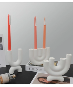 Detail of white matte ceramic candle holder with minimalist geometric U-shaped curves
