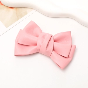 Detail of pink faux leather pleated bow accessory with soft textured surface