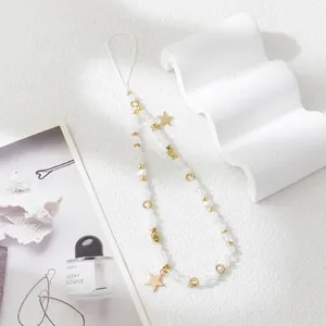 Close-up of handmade beaded phone strap with white beads and golden star pendant