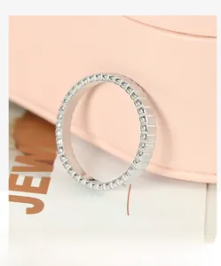 Macro detail of silver gear pattern ring with geometric pyramid studs on soft background