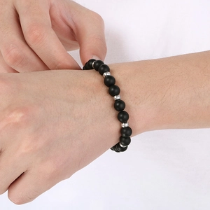 Détail de perles d'agate noire mate avec des séparateurs en métal argenté au poignet