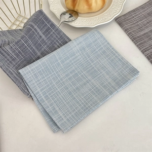 Dettaglio delle tovagliette in cotone e lino a quadretti blu e a righe blu scuro