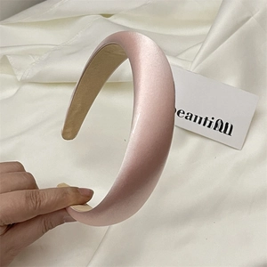 Close-up of pink padded satin headband with elegant silk texture and glossy finish