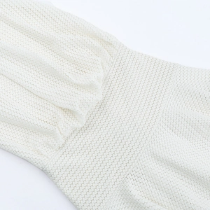 Detailed macro view of white textured crochet hollow-out fabric for holiday dress