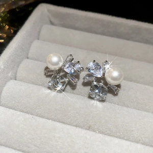 Macro shot of silver ear cuff with white pearl and sparkling zircon in a gray jewelry box