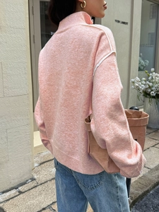 Detail of pink knitted sweater back view with white shoulder stripes on female model