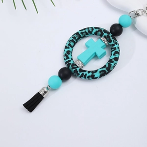 Detailed close-up of silicone bead keychain with cross pendant and black tassel