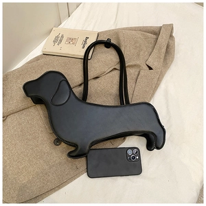 Detail of creative black dachshund dog shaped handbag placed on a khaki suit jacket