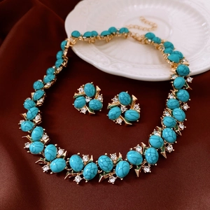 Detail of vintage turquoise jewelry set with zircon stones on brown silk fabric