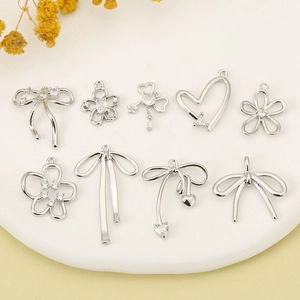 18K gold plated bow and heart pendants with cubic zirconia on a white display tray