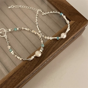 Detail of silver beads and blue stones with OT clasp on luxury velvet jewelry tray