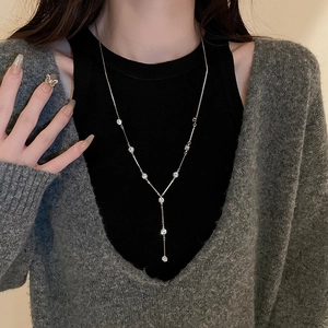Detail of silver Y-shaped sweater necklace with sparkling rhinestones on model
