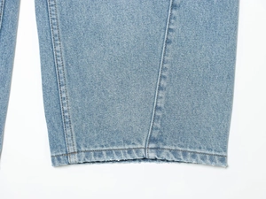 Dettaglio ravvicinato dell'orlo dei jeans in denim di cotone azzurro con cuciture a vista