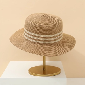 Women's wide brim straw sun hat with white stripes on an elegant gold display stand