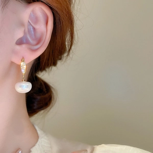 Gros plan de boucles d'oreilles vintage en perles dorées avec zircons sur le mannequin