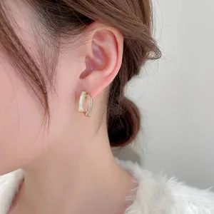 Modern gold-plated C-shaped earrings with rows of white zircons and shell stones