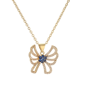 Detailed view of a gold-plated butterfly pendant with sparkling blue and clear crystals