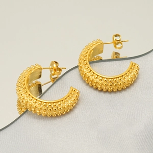 Detail view of gold geometric hoop earrings with unique textured granular finish