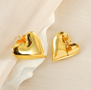 Macro shot of 18K gold plated 3D heart stud earrings with a high-polished metallic finish