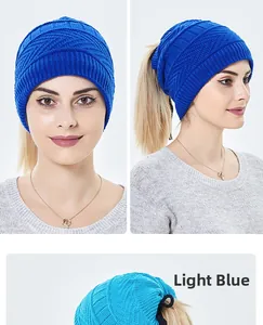Detailansicht einer hellblauen Strickmütze mit Zopfmuster und Öffnung für Pferdeschwanz