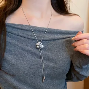 Detail of long pearl petal pendant necklace with silver chain on model's neck