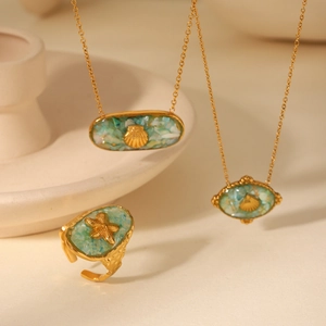 Detailed set of gold ocean jewelry with turquoise shell necklaces and starfish ring