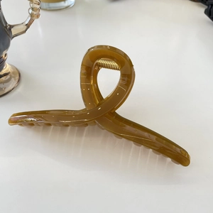 Detail of amber tortoiseshell claw clip with strong gold metal spring and twisted design