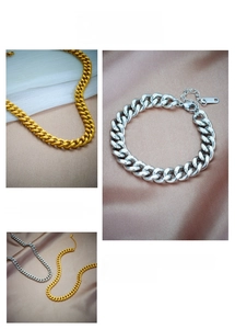 Detailed view of polished gold and silver Cuban link chains on elegant satin background